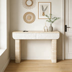 Modern beige console table with textured white drawers and sturdy stone-look base, set in a minimalist entryway.