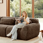 Woman relaxing on chocolate plush modular sofa with movable ottoman, highlighting comfort and cozy seating in a bright living room.