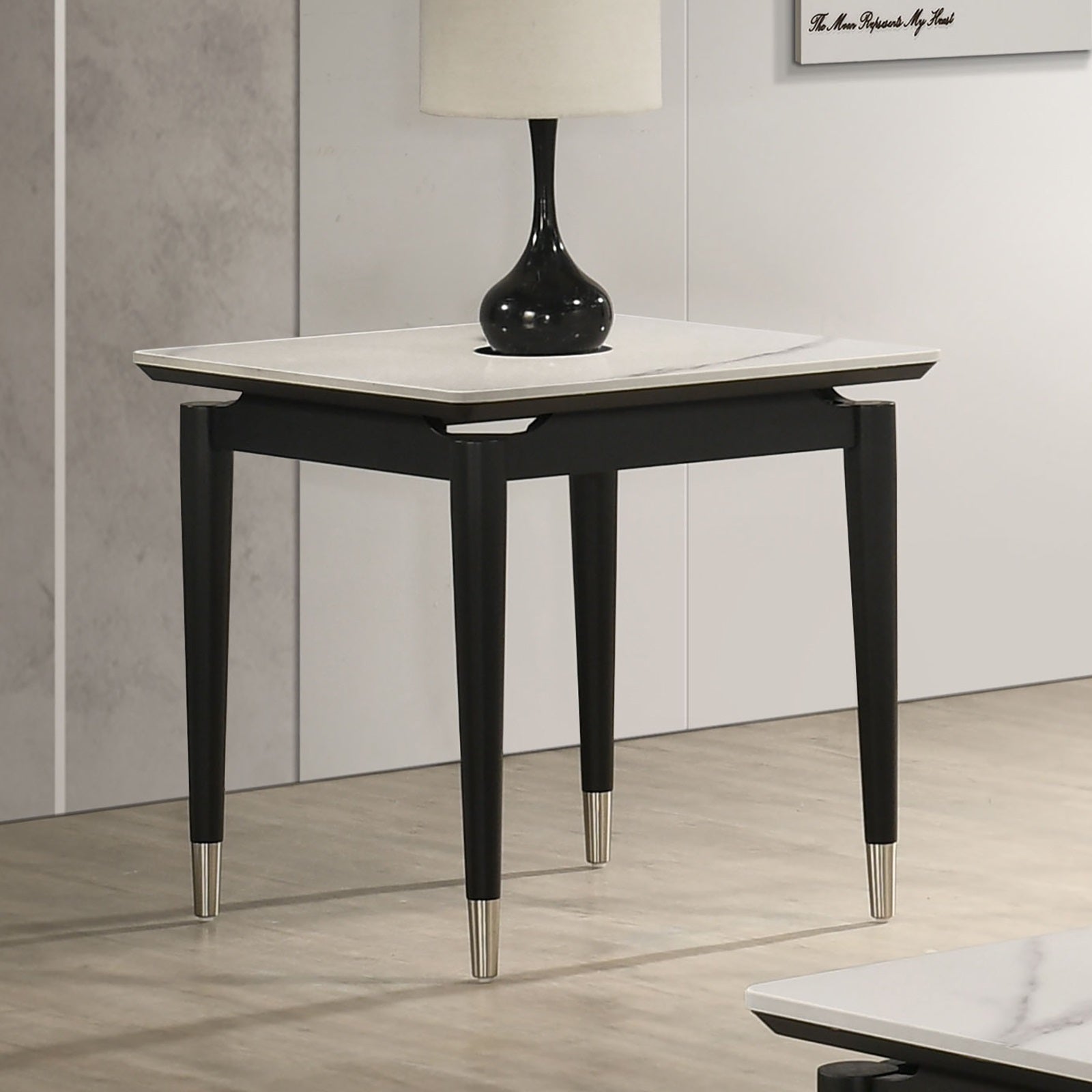 Contemporary Sintered Stone End Table with arrow legs and silver-capped feet, styled in a modern living room corner.