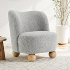Modern gray upholstered accent chair in boucle fabric with curved backrest and wooden ball legs, perfect for stylish interiors.