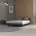 Nimmo twin bed frame in smokey oak with a low-profile, modern minimalist design set against a wood slat wall.