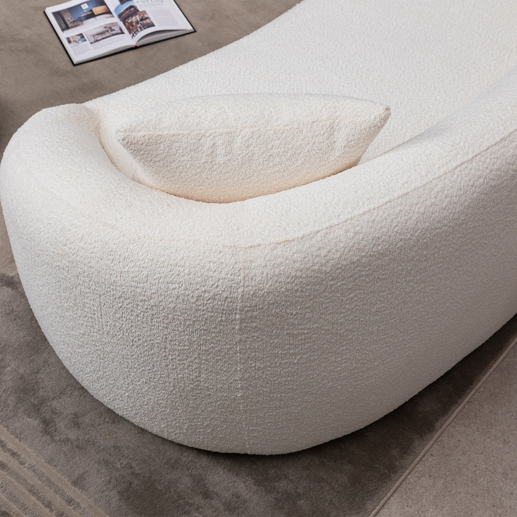 Detail of the armrest and cushion on minimalist white curved sofa, emphasizing its rounded modern design.