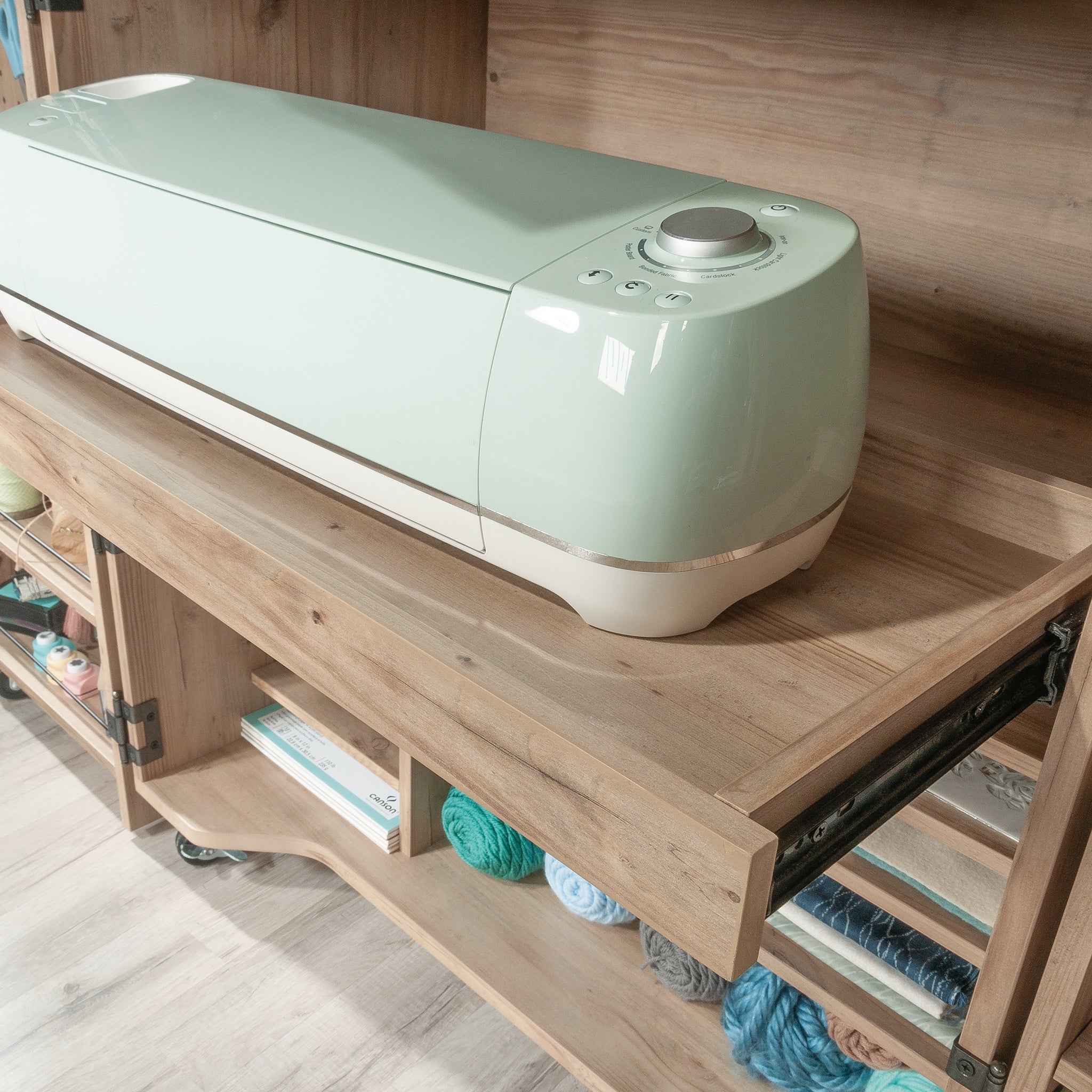 Slide-out tray in Craft Cart with Storage for Home holding a cutting machine, ideal for crafting and tool access.