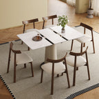 Expandable dining table set with rock slab top and six wooden chairs, ideal for modern apartments and adaptable for space-saving needs.