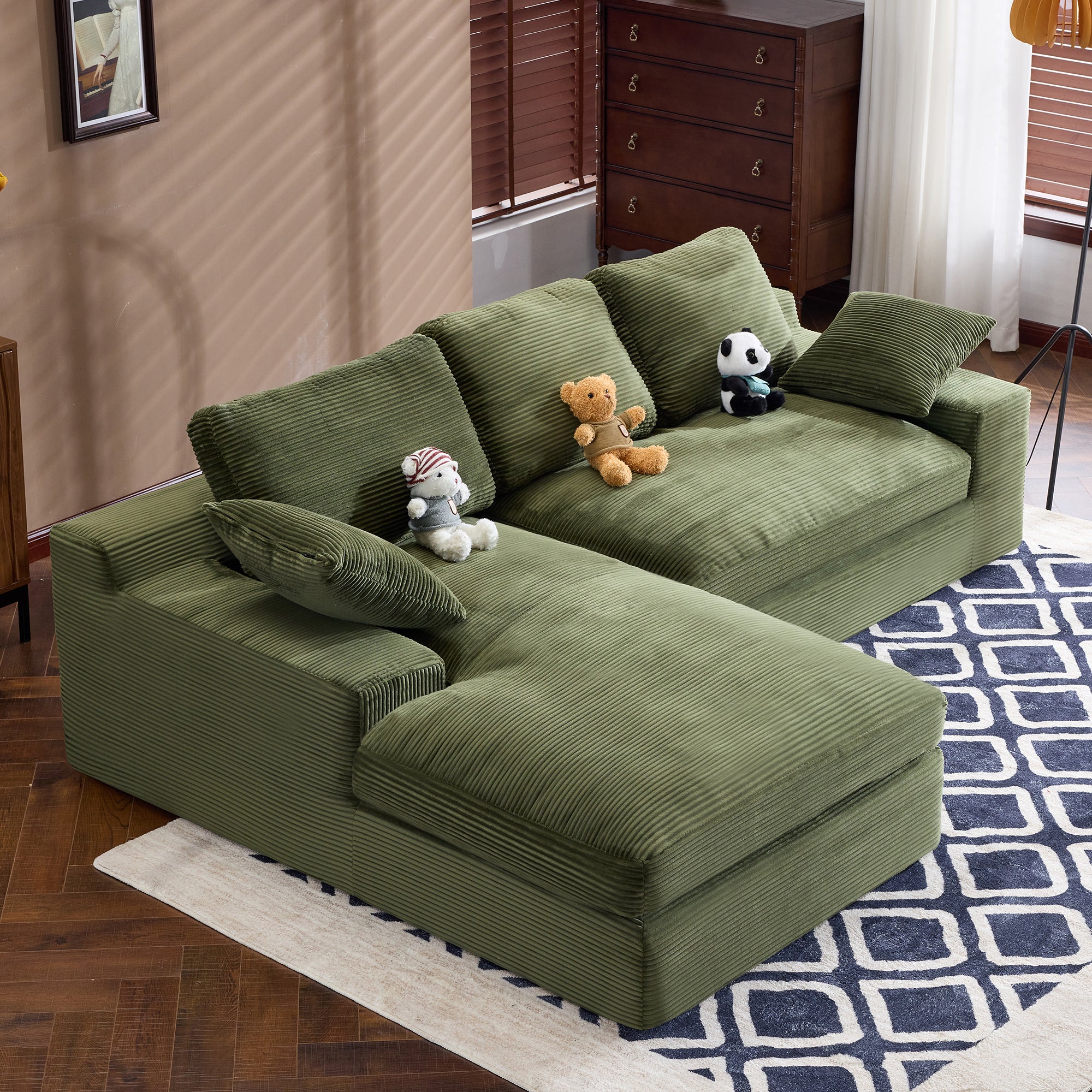 Green Corduroy Sofa - Plush Comfort | 4 Seat Modern Design with L-shape layout, soft fabric, and decorative plush toys.