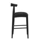 Side profile of black fabric bar stool with padded seat and angled backrest, highlighting ergonomic comfort and sleek silhouette.