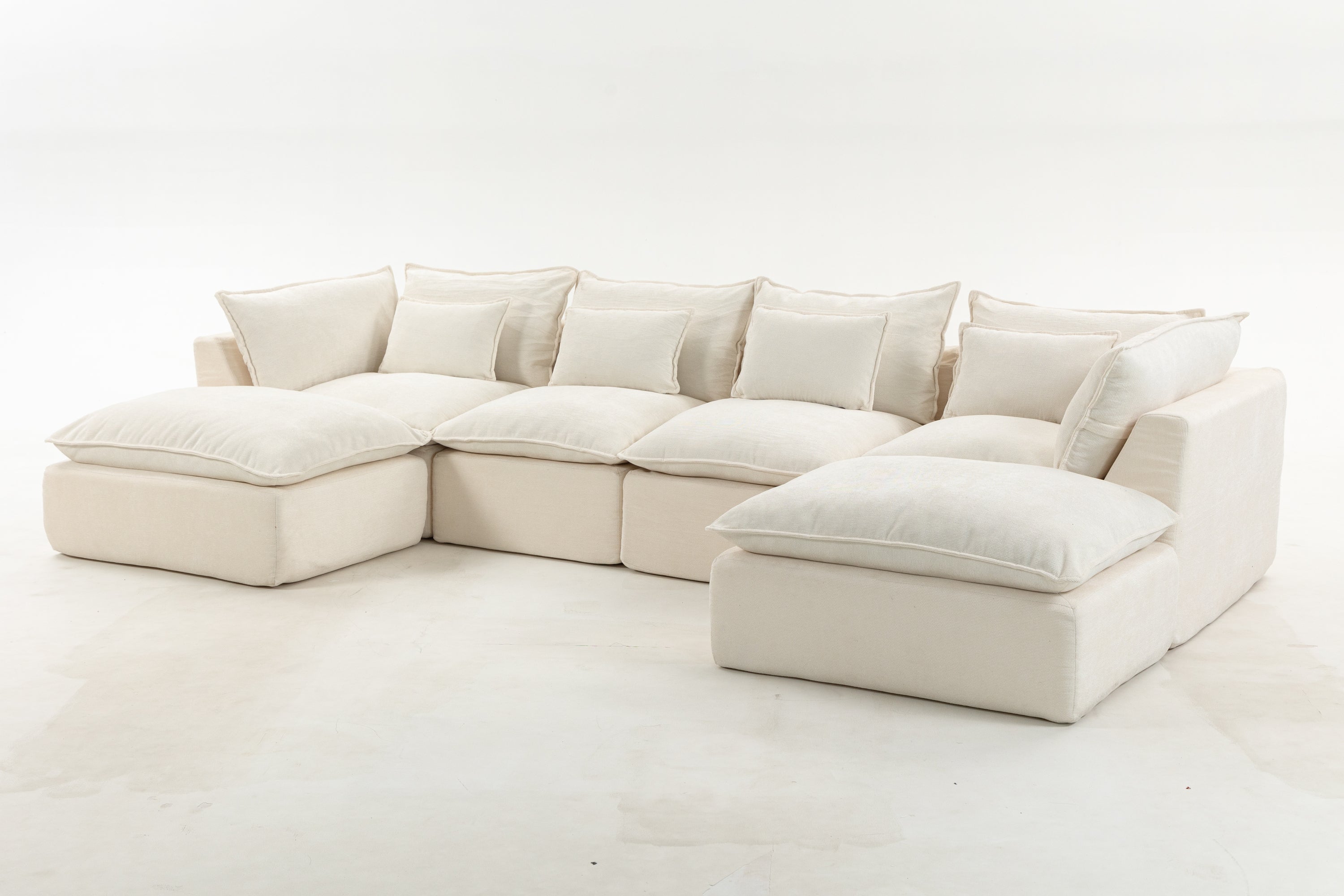 Oversized modular sectional sofa with deep cushions and wide seating. Features 4 seats and 2 ottomans in a soft, cloud-like design.