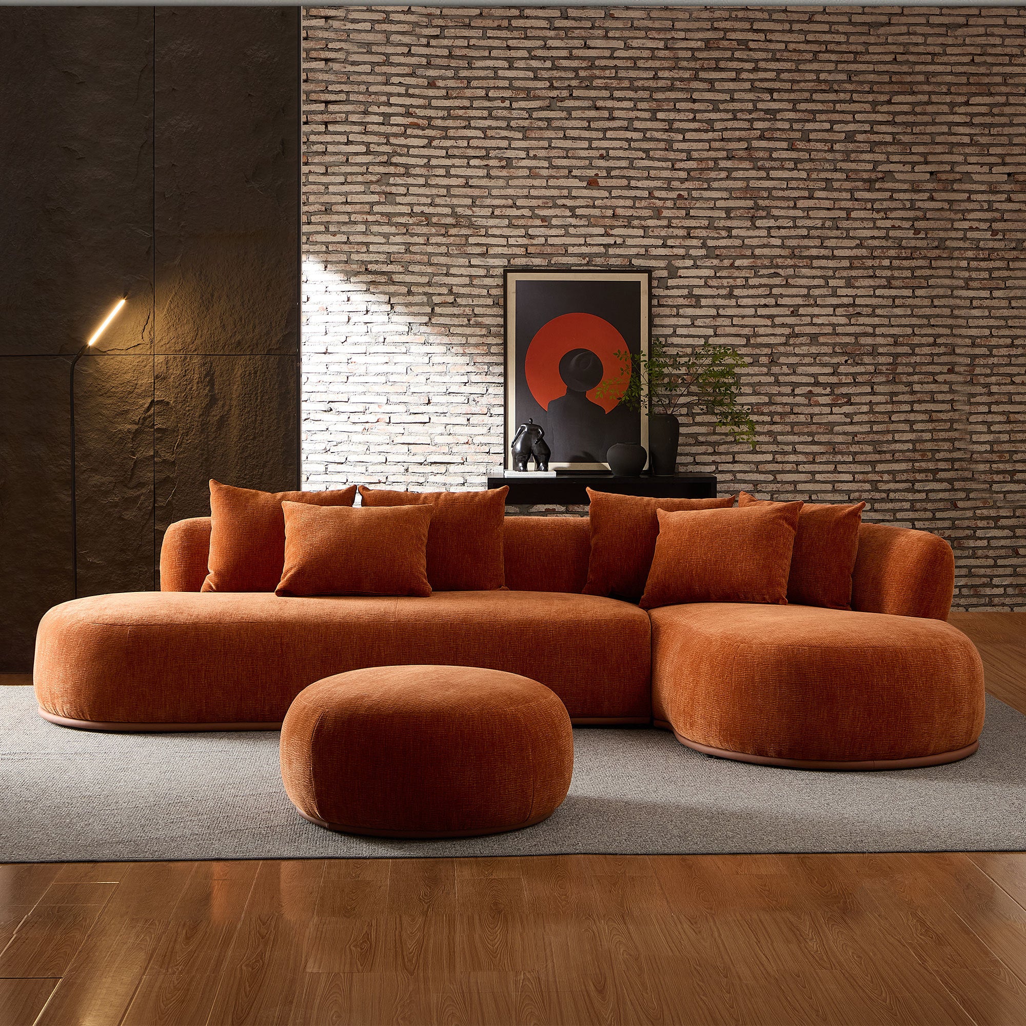 Contemporary oversized orange sectional sofa with ottoman in a loft-style room, perfect for large living spaces and modern decor.