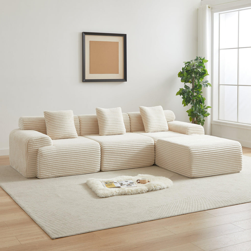 Modular corduroy sofa in cream set in a bright living room. 114-inch sectional offers flexible seating with no assembly required.