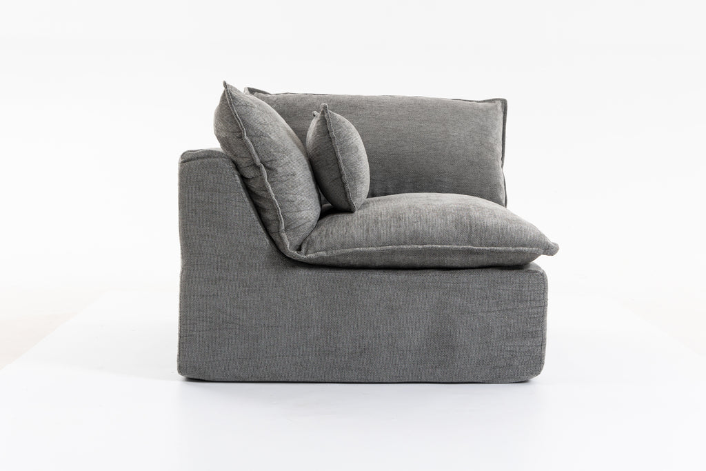 Side profile of the oversized modular sectional couch showing thick cushions and supportive armrest in grey velvet.