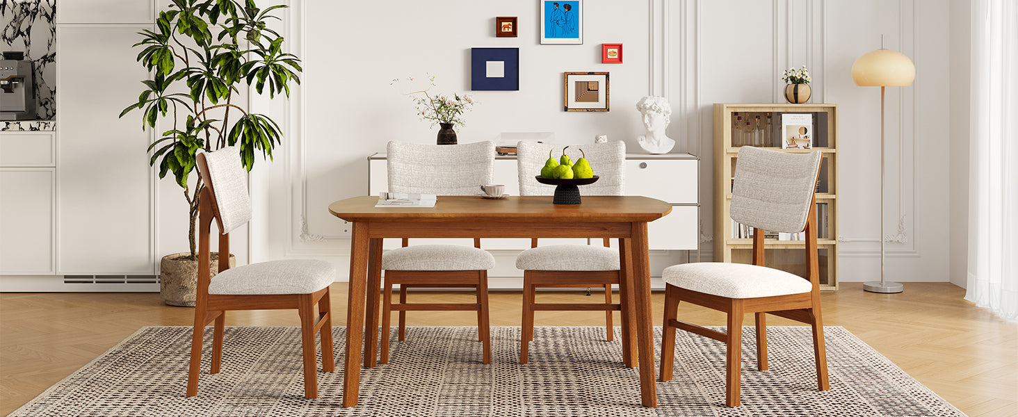 Front-facing view of farmhouse dining table set with 4 upholstered chairs, styled in a bright, modern dining space.