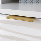 Close-up of gold drawer pull on White Coastal Credenza, emphasizing the modern hardware and textured drawer design.