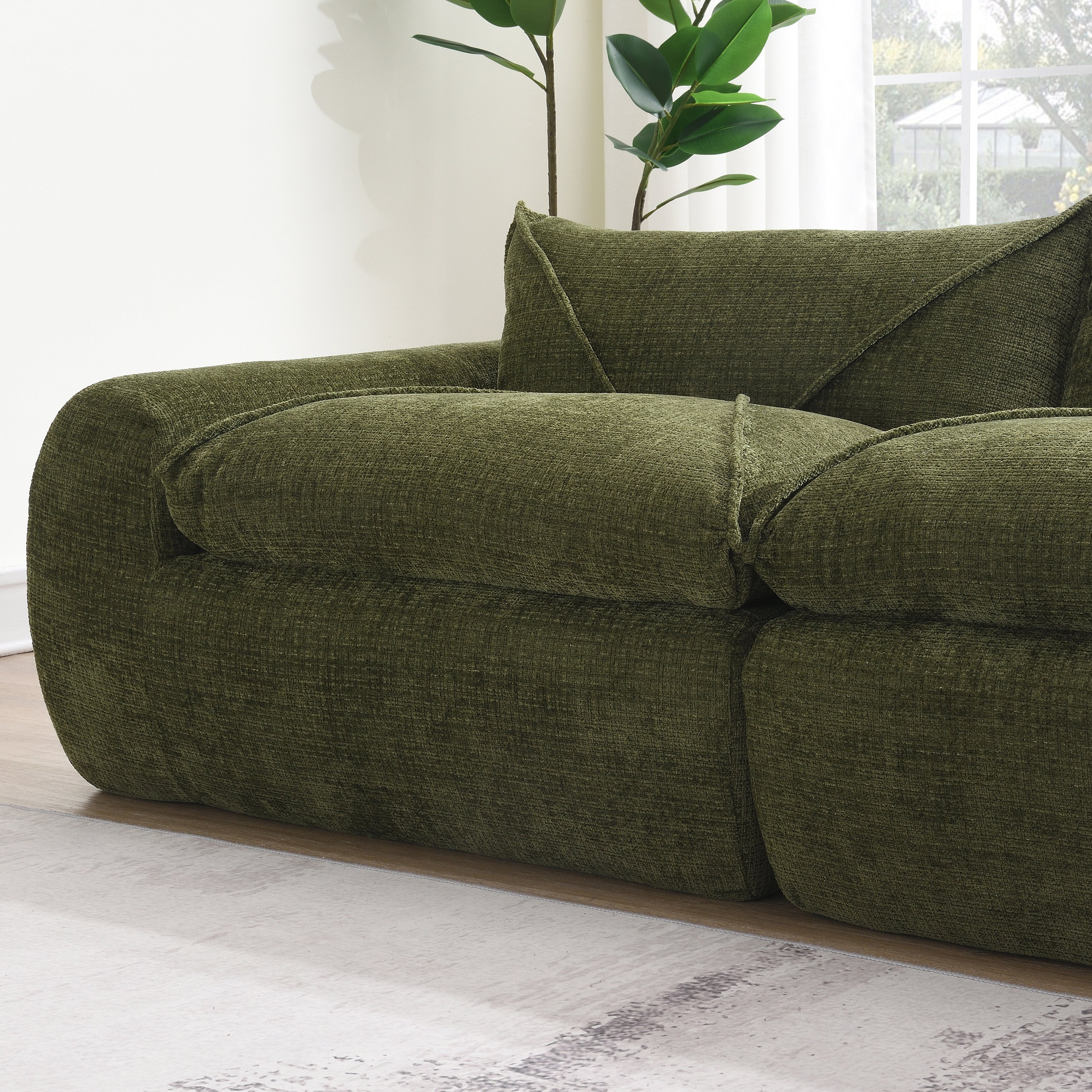 Close-up of armrest and cushion on 116'' compressed sofa, showing textured green fabric and high density foam comfort.