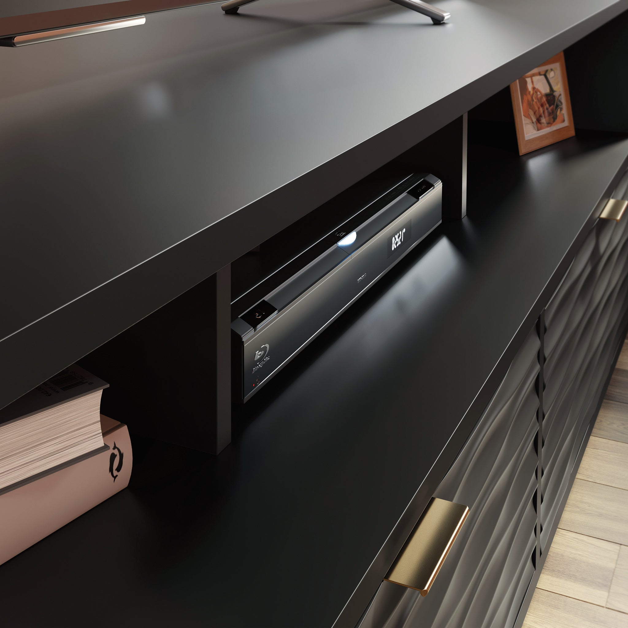 Close-up of black credenza shelf holding a Blu-ray player and books, showcasing open compartment for electronics.