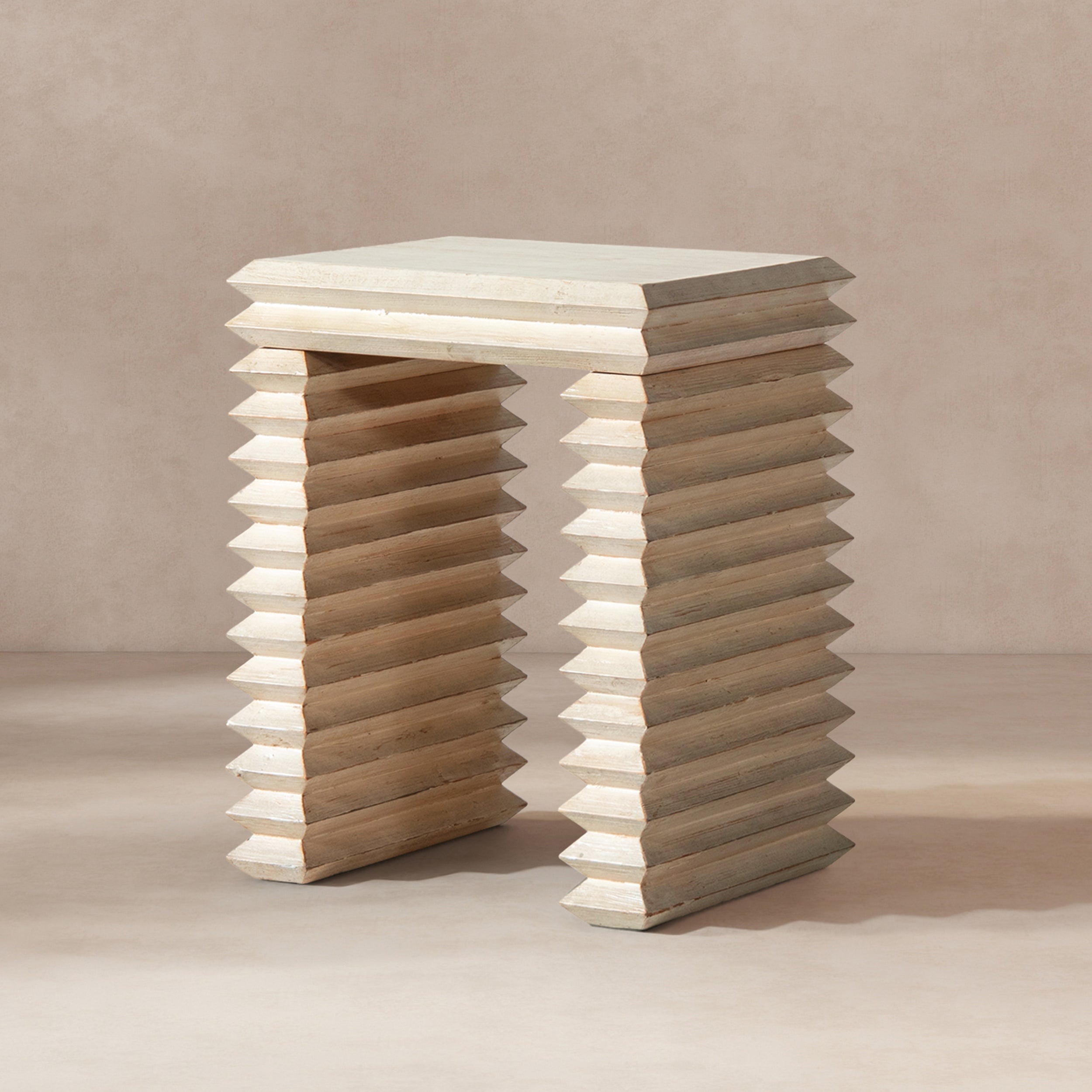 Whitewashed reclaimed pine side table featuring a geometric, stacked waterfall design with sharp, ribbed edges.