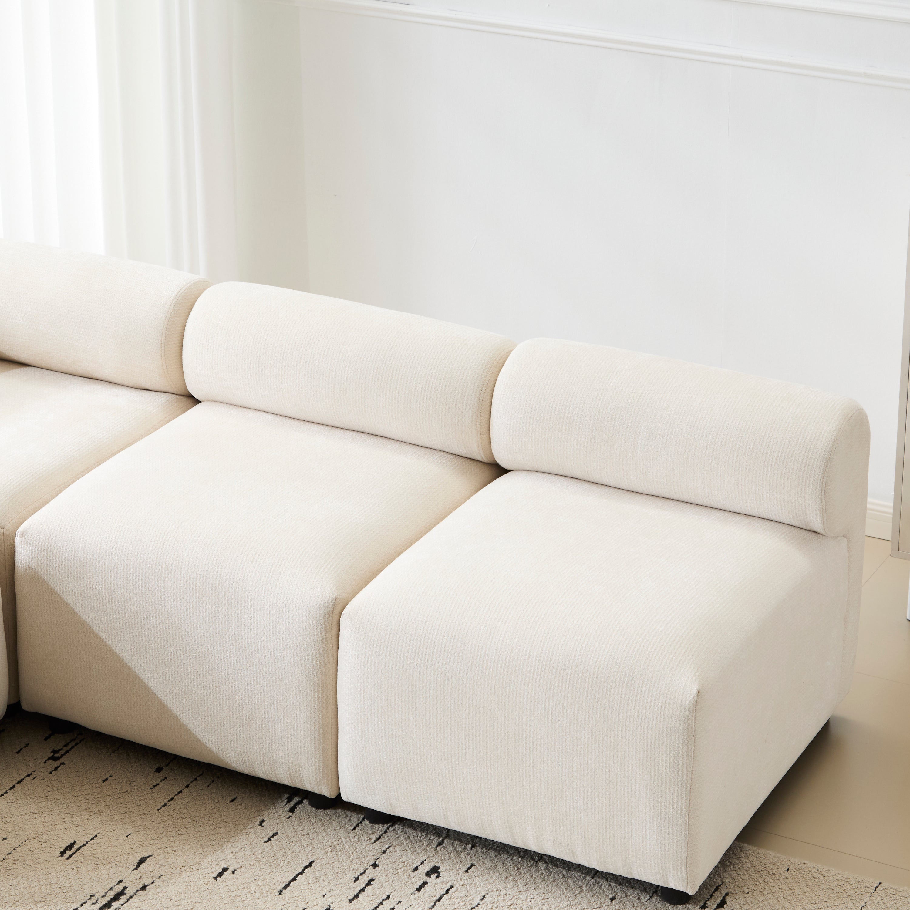 Close-up of the Evelyn sectional sofa's chenille fabric and armless middle seat, showcasing soft texture and modular design.