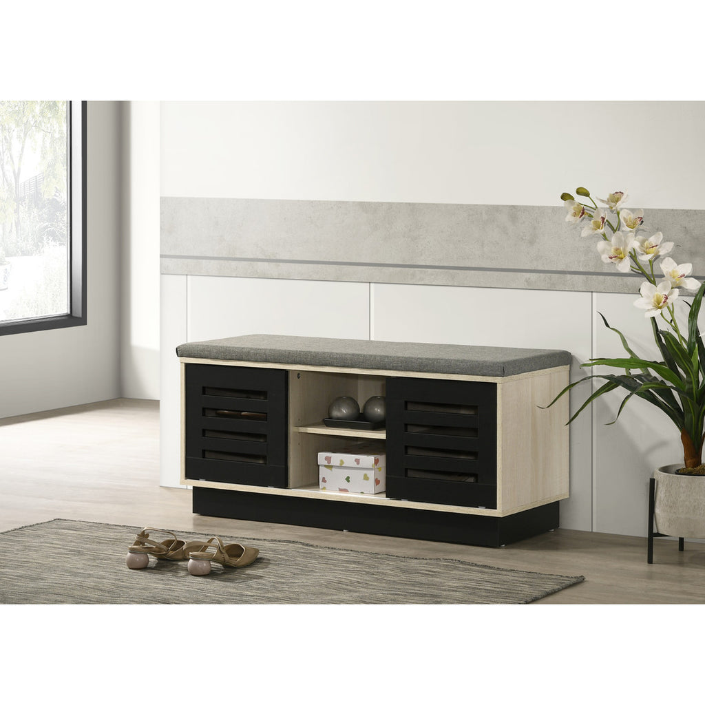 Oak shoe cabinet with sliding black doors and cushioned top, placed in a modern hallway for stylish and functional shoe storage.