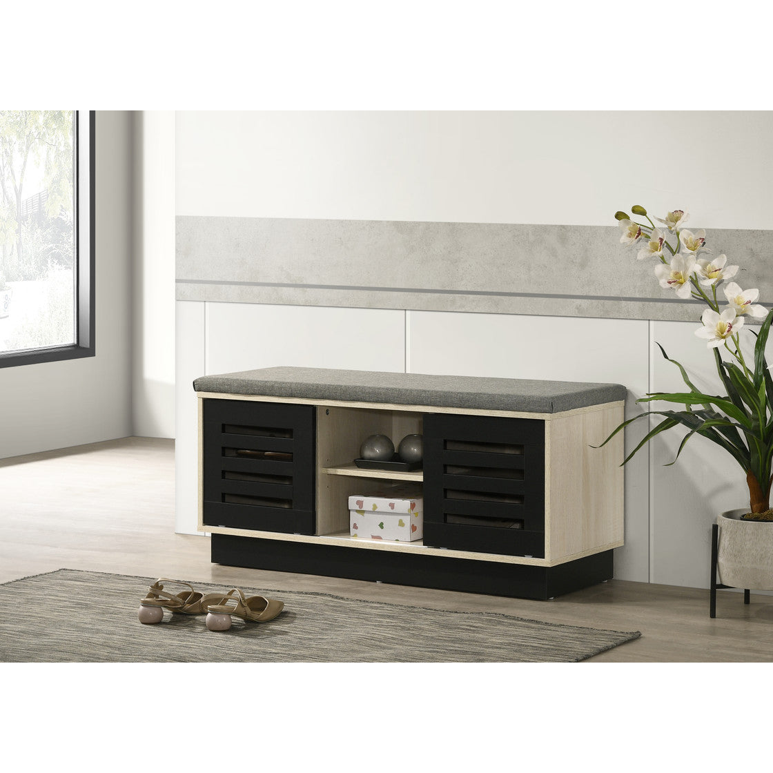 Oak shoe cabinet with sliding black doors and cushioned top, placed in a modern hallway for stylish and functional shoe storage.