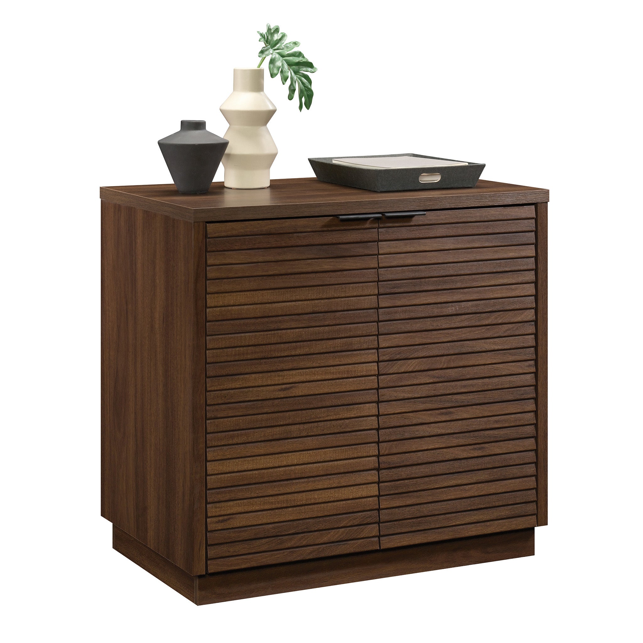 Angled view of Library Base, Brown finish cabinet with decorative items on top, ideal for modern office or home use.