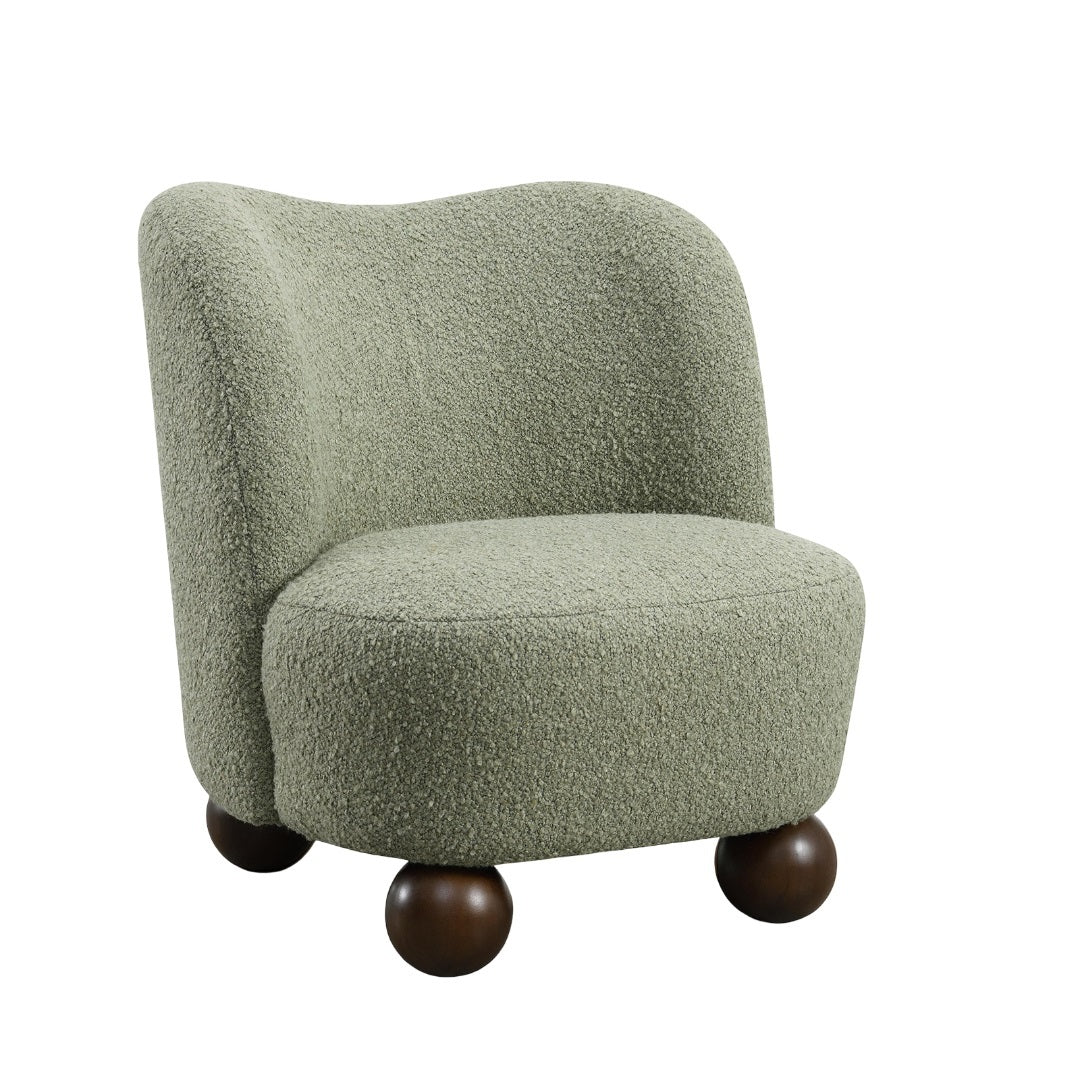 Standalone green boucle fabric chair with sculpted back and ball feet. Modern accent seating with plush comfort and unique design.
