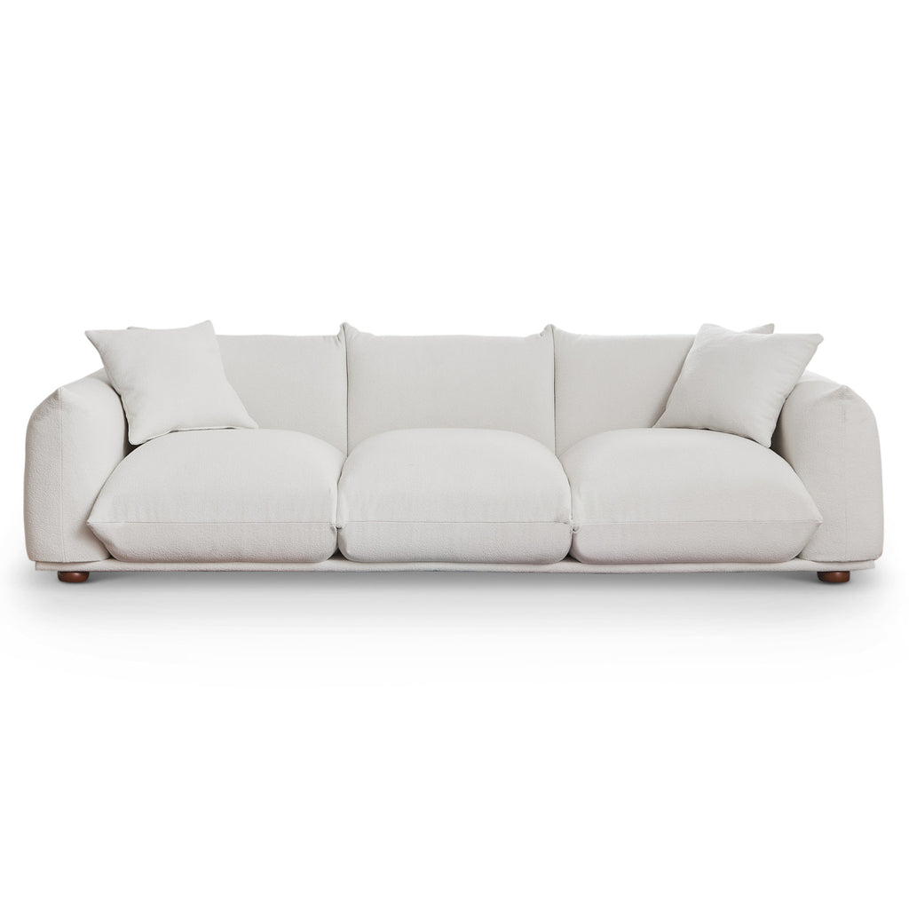 Modern 100-inch cream boucle sofa with deep cushions, two matching throw pillows, and low-profile solid wood legs.