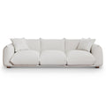 Modern 100-inch cream boucle sofa with deep cushions, two matching throw pillows, and low-profile solid wood legs.