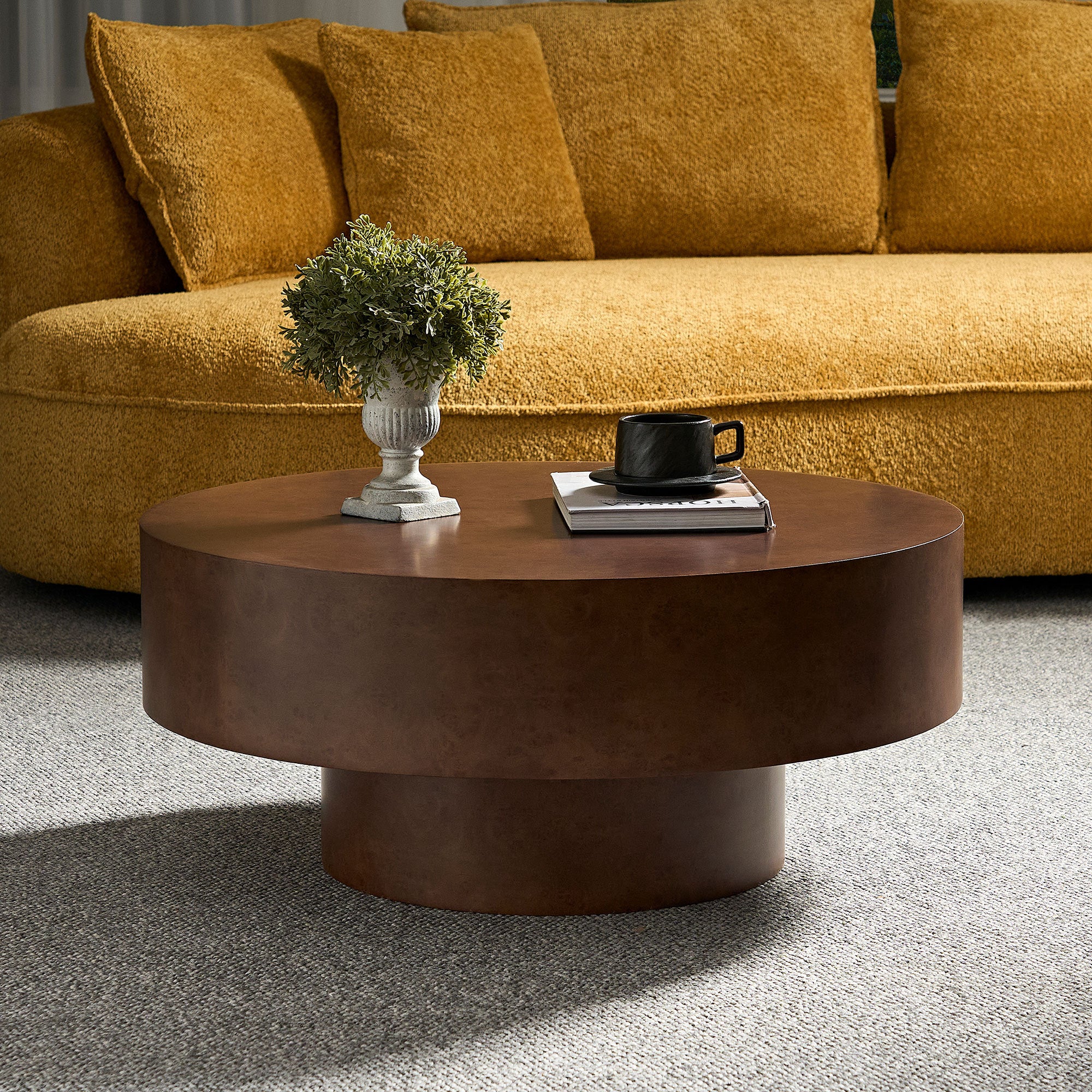 Round Faux Burl Coffee Table with sturdy pedestal base, styled in a cozy living room with mustard sofa and neutral rug.