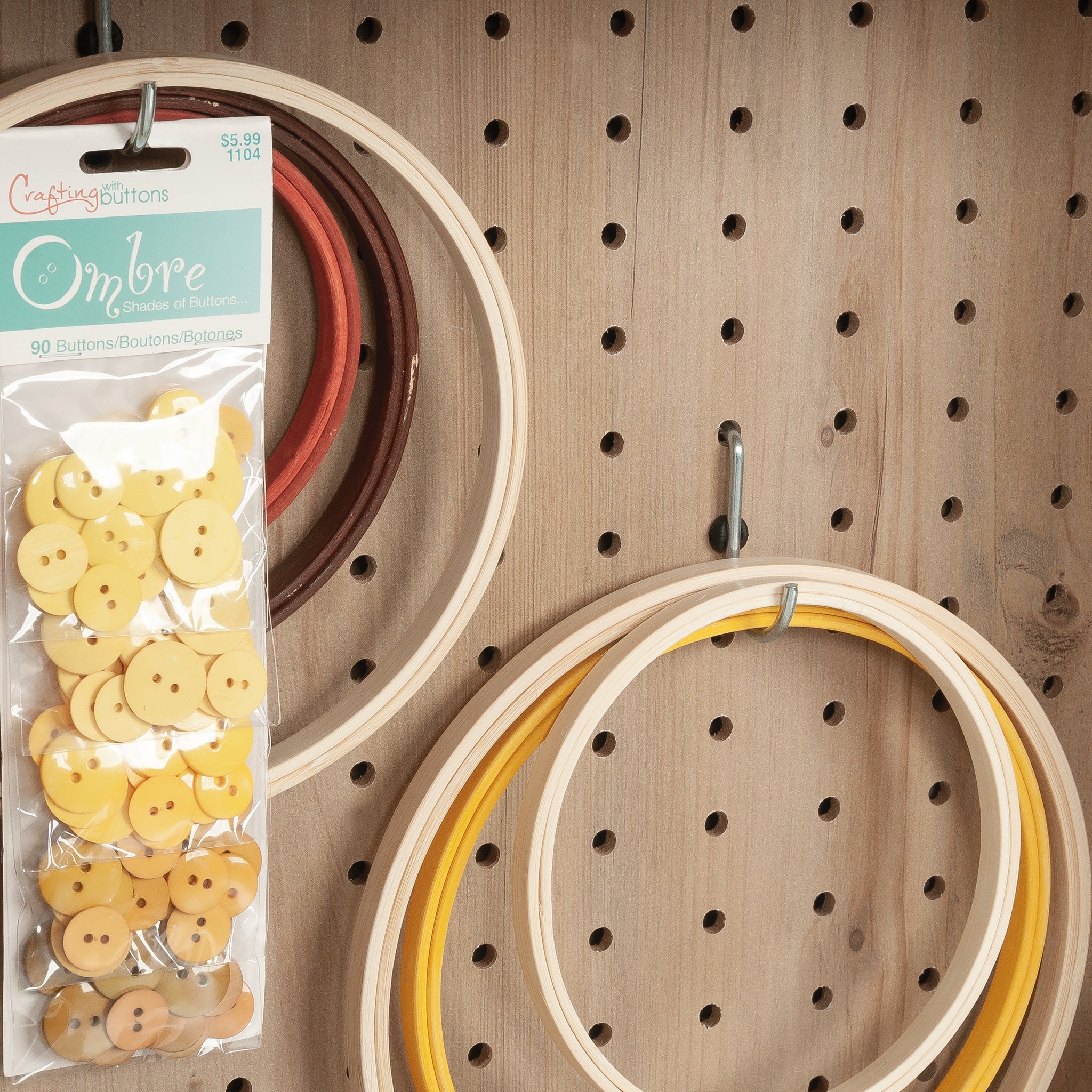 Pegboard in Craft Cart with Storage for Home holding embroidery hoops and buttons, ideal for craft supply organization.