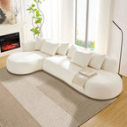 Modern Oversized L-Shape Sectional Sofa Beige with chaise lounge, placed near large windows and a fireplace, styled with throw pillows and blanket.