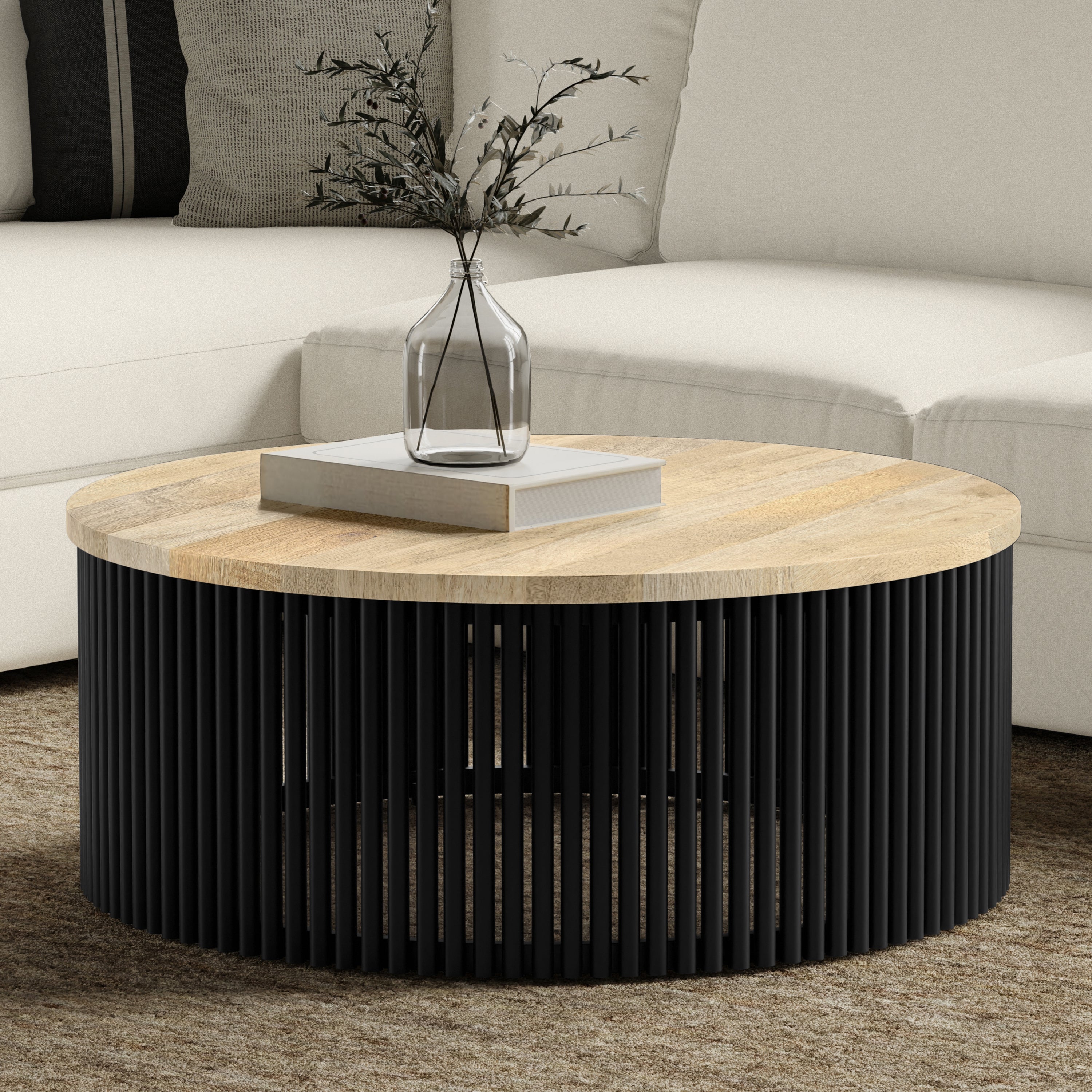 Demy Coffee Table - Wood Metal Coffee Table with round mango wood top and black slatted iron base, styled in a modern living room.