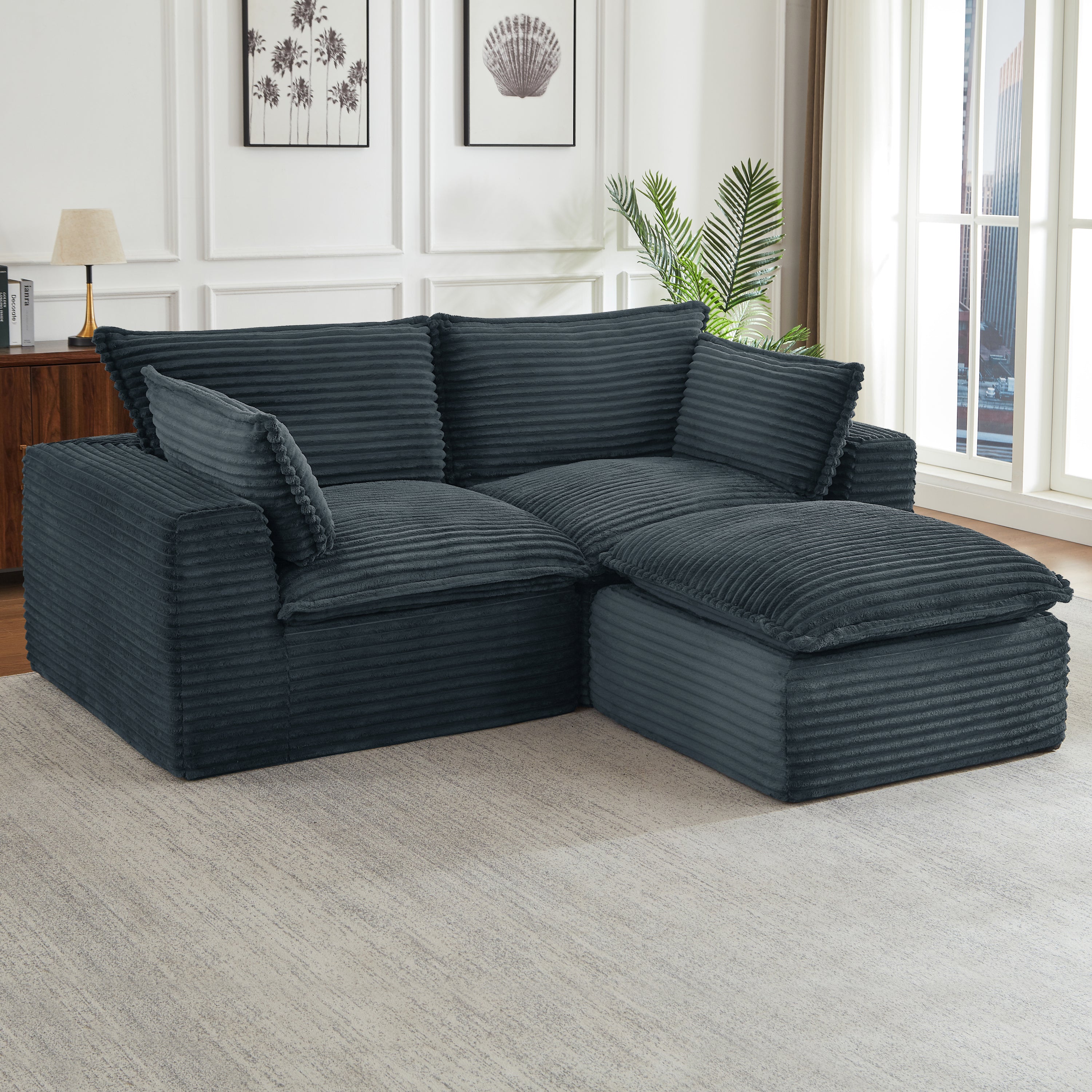 Oversized, dark gray corduroy modular sectional sofa with deep, plush cushions in a modern living room setting.