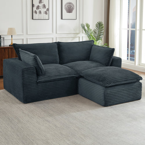 Oversized, dark gray corduroy modular sectional sofa with deep, plush cushions in a modern living room setting.