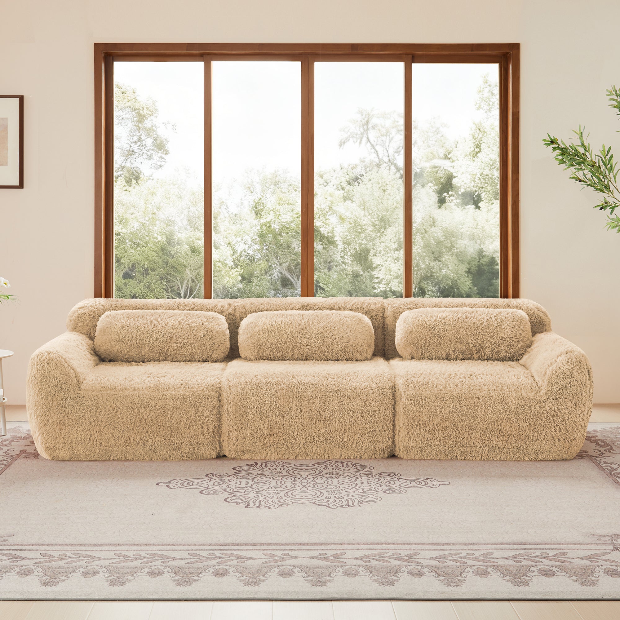 Plush fabric modular sectional sofa with four seats and lumbar pillows, set against a large window for a cozy home interior.