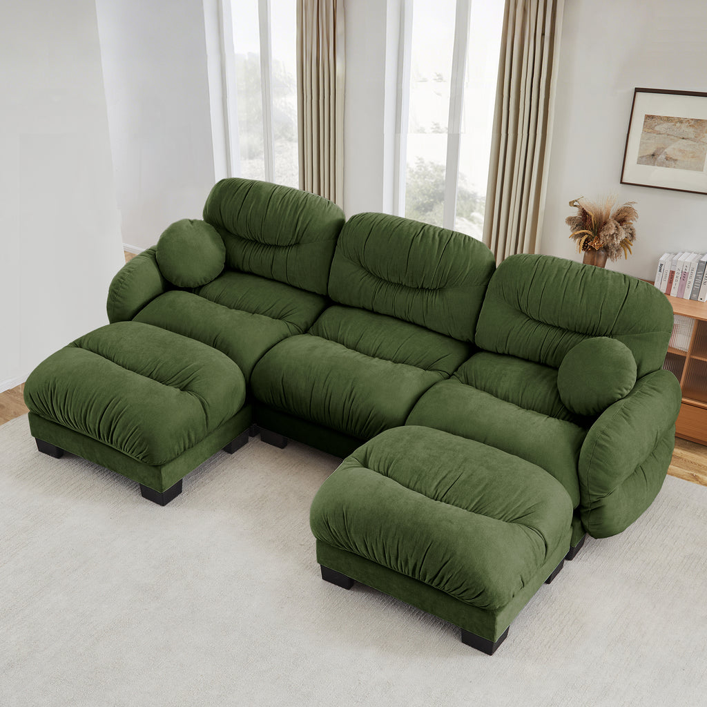 U-shaped modular sectional sofa in green chenille, featuring pleated detailing, two ottomans, and round throw pillows.