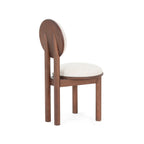 Three-quarter rear view of beige dining chair. Shows curved wooden backrest supports and seamless upholstery.