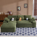 Green corduroy sofa with cushions and pillows on geometric rug, ideal for cozy living rooms. Soft foam filler and plush texture enhance comfort.