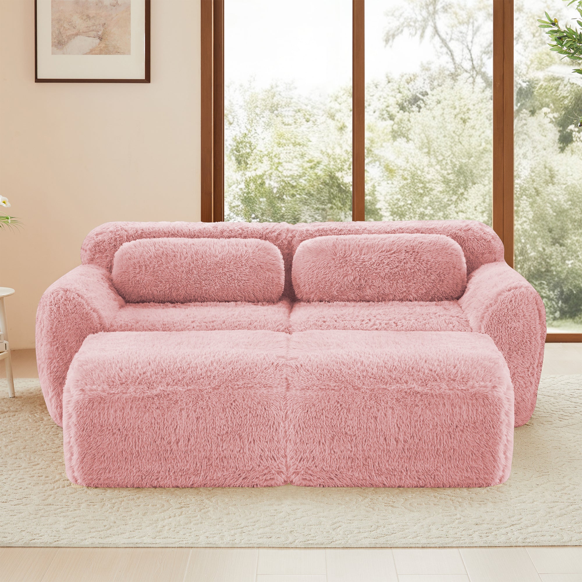 Front view of pink modular plush sofa with ottoman, showcasing its soft texture and deep seating ideal for stylish and comfortable living spaces.