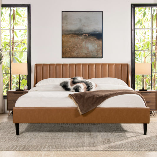 King faux leather platform bed with vertical tufted headboard in caramel tan brown, styled in a modern bedroom with natural light.