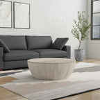 Rustic white Elmbrook Drum Coffee Table styled in a minimalist living room with neutral tones and a potted plant, enhancing modern interior aesthetics.