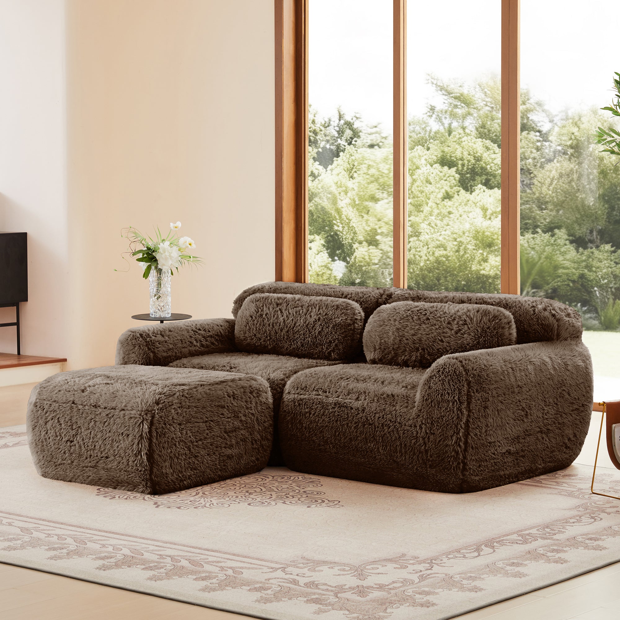Angled view of L-shaped modular sofa in plush chocolate fabric, featuring ergonomic contours and a matching ottoman.