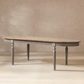 Oval reclaimed pine dining table with a natural wood top, antique blue-grey fluted apron, and elegant tapered legs.