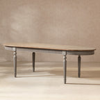 Oval reclaimed pine dining table with a natural wood top, antique blue-grey fluted apron, and elegant tapered legs.