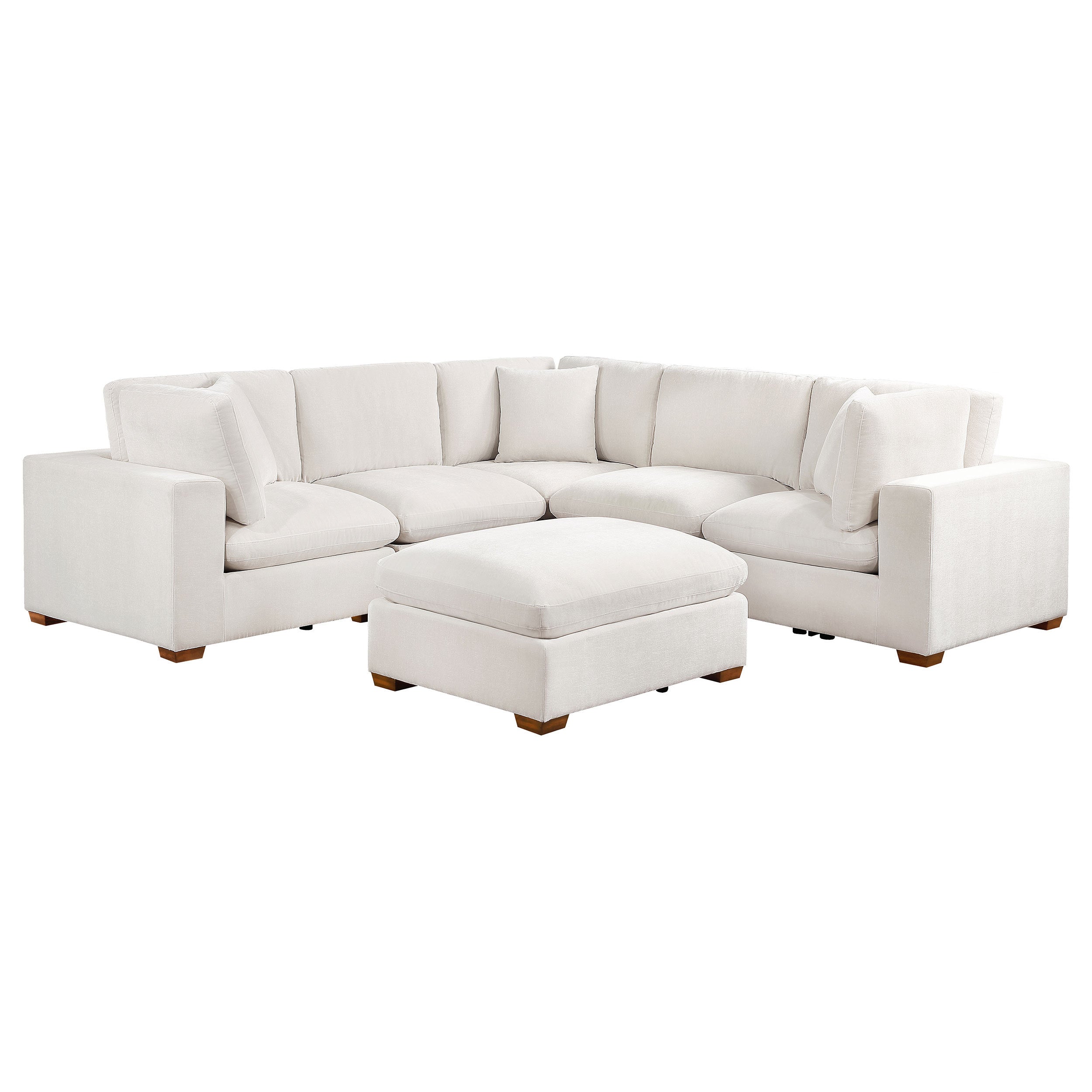 Ivory 6-piece modular sectional sofa upholstered in fabric with tapered wooden legs and a matching ottoman.
