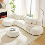 Oversized L-shape sectional sofa with ottoman in beige, arranged in a cozy living room with fireplace and modern decor.