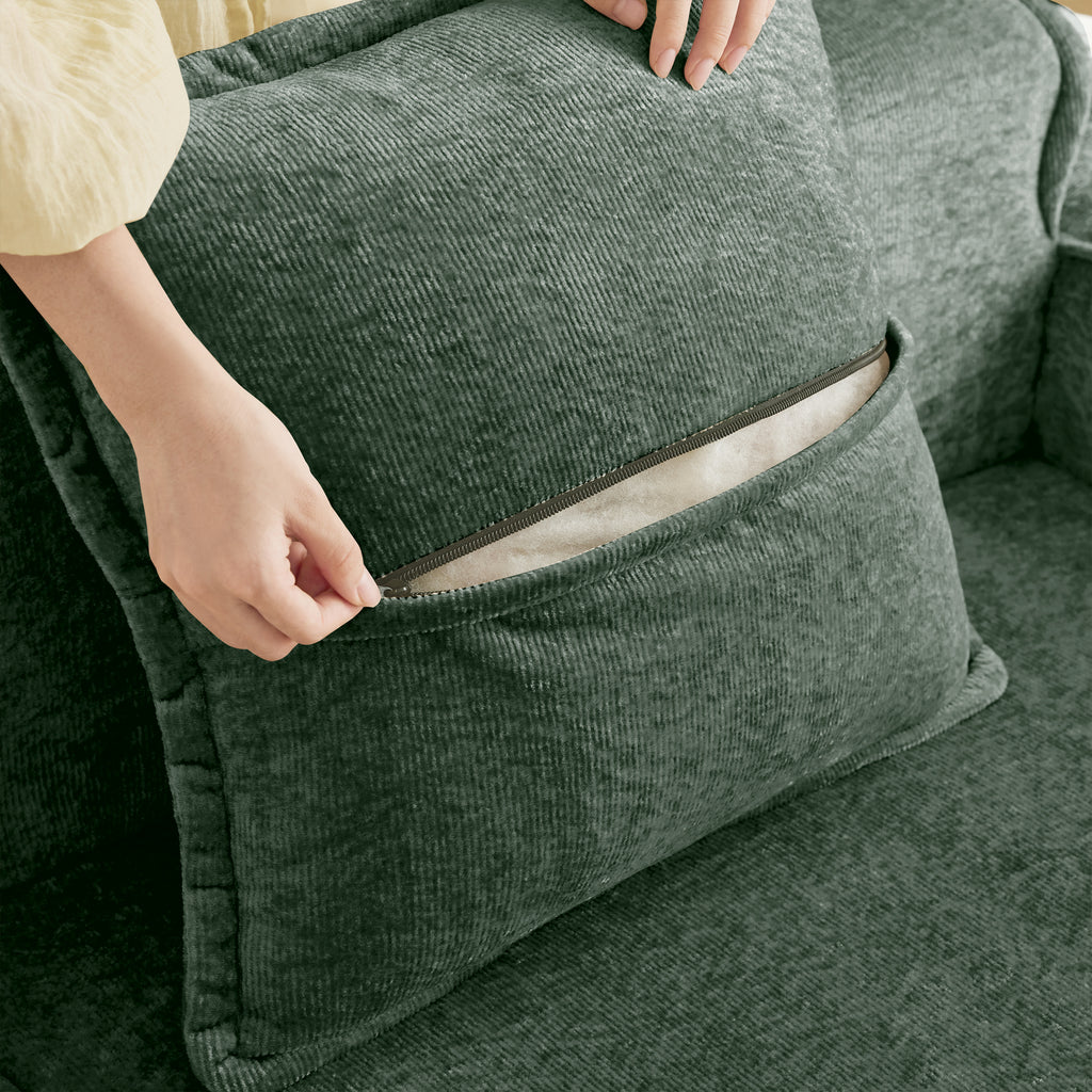 Zippered throw pillow on the Modular Green Sofa, revealing removable cover for easy cleaning and maintenance.
