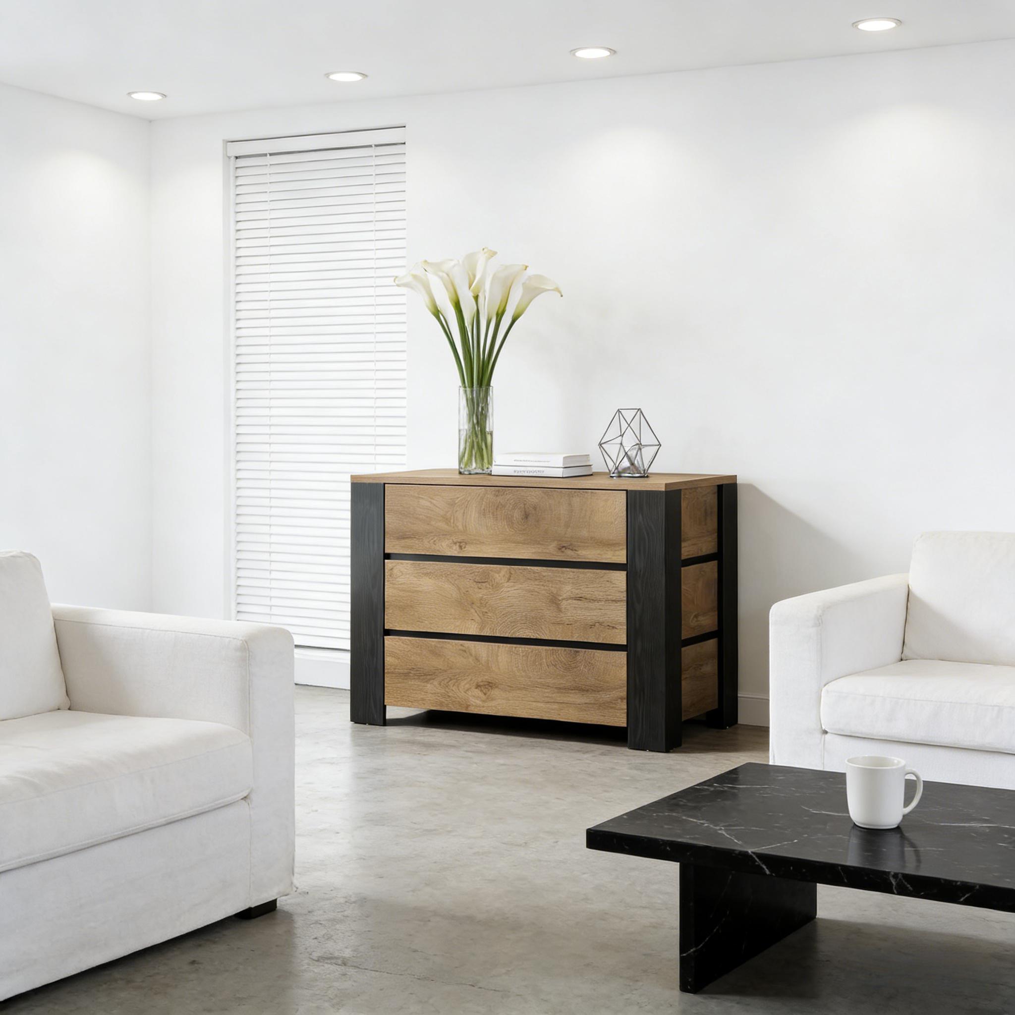 Modern three-drawer storage nightstand in oak wood finish with matte black frame and accents in a minimalist room.