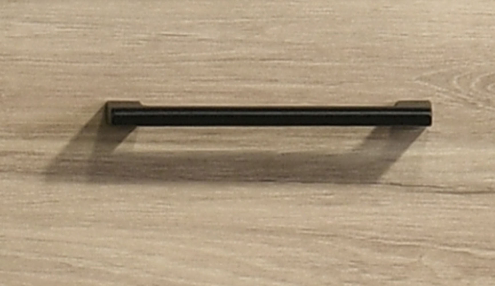 Close-up of black handle on Light Oak 4-Drawer Chest emphasizing modern hardware design and easy drawer access.