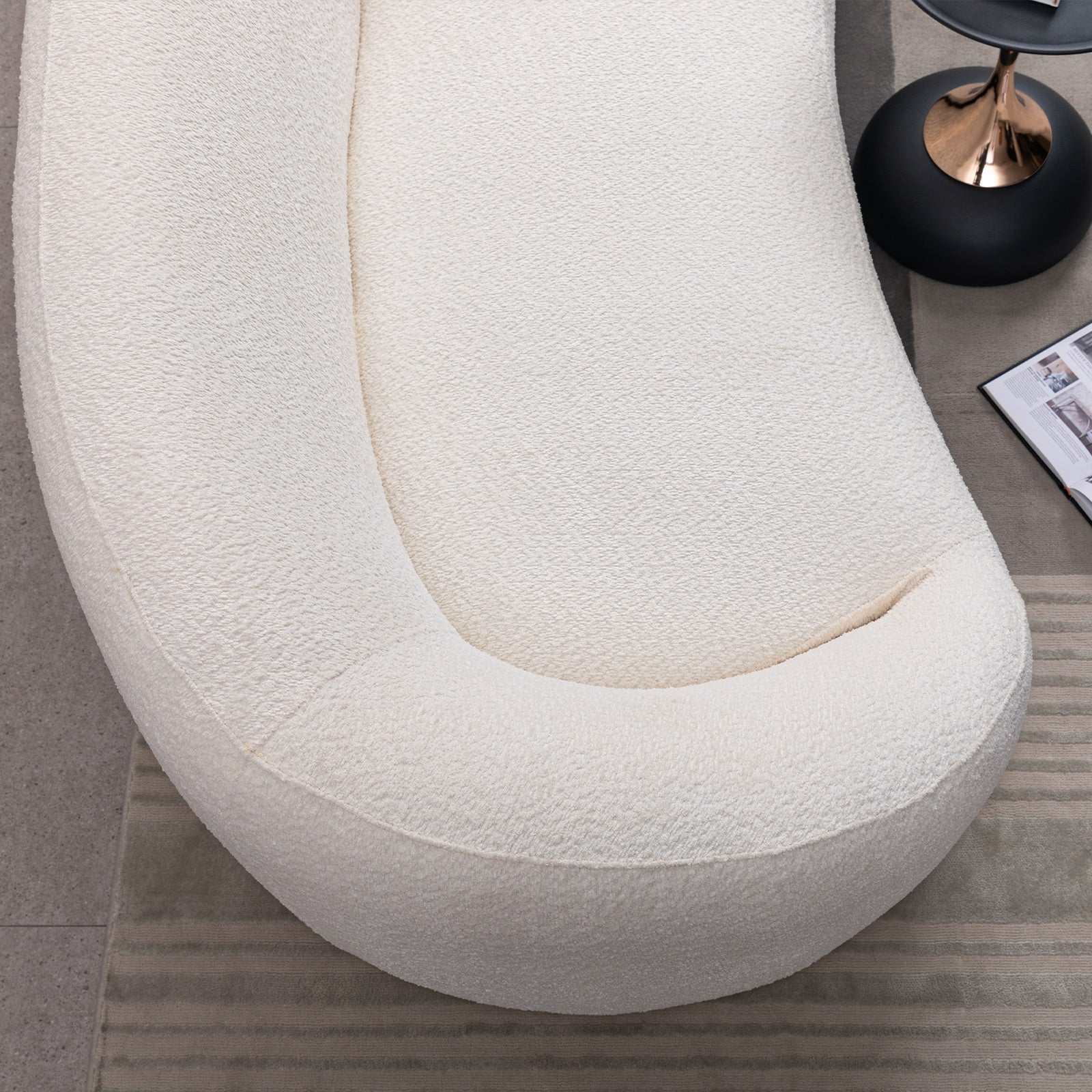 Top view of modern white curved sofa highlighting its smooth contours and spacious seating area.
