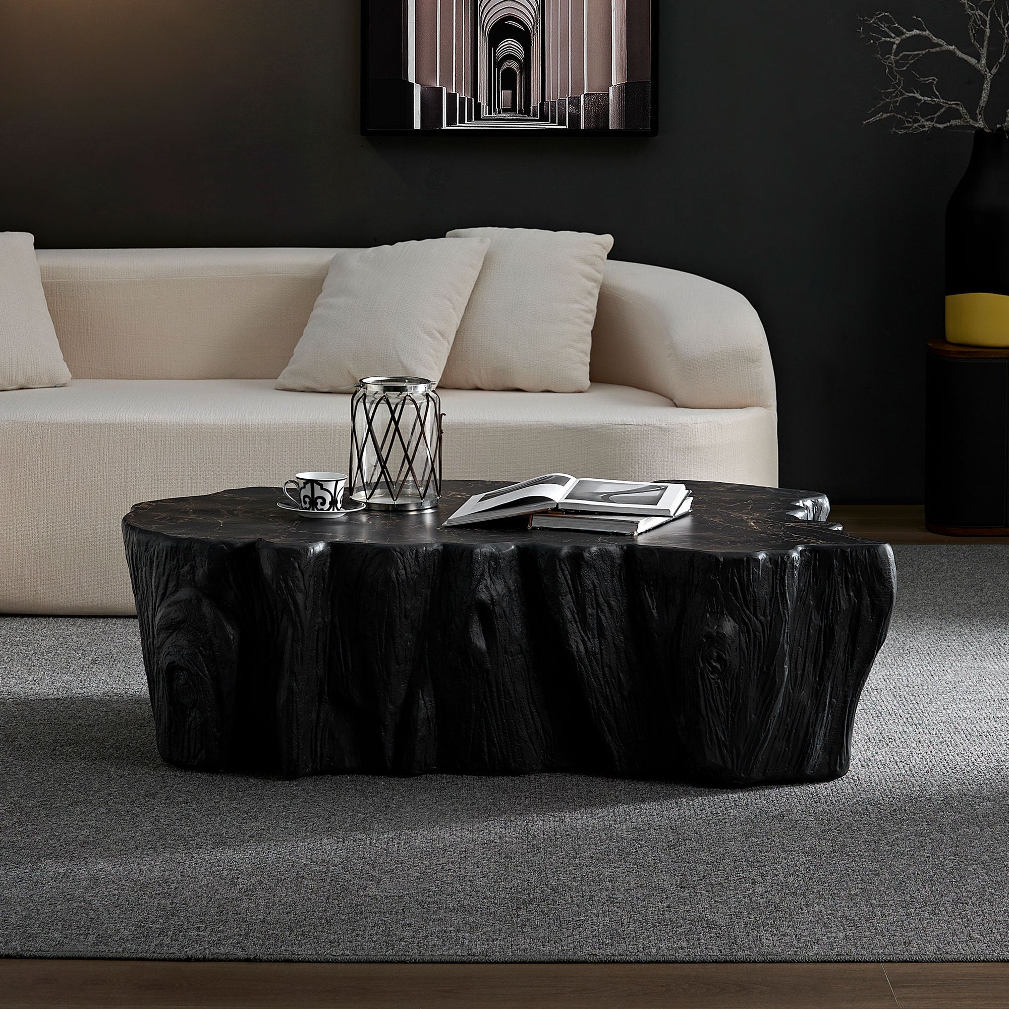 Mid-century modern coffee table made of black fiberglass with marble top, styled in a dark-toned living room for a bold, contemporary look.