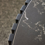 Edge detail of the modern round coffee table showing fluted wood texture and smooth sintered stone top with natural veining.